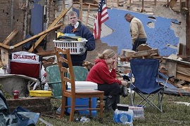 Resident Taylor Tennyson sits in the front yard as family members salvage the remains from their home which was left devastated by a tornado in Moore, Oklahoma