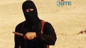 Still image from video shows a masked, black-clad militant, who has been identified by the Washington Post newspaper as Emwazi, standing next to a man purported to be Sotloff