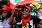 Migrant domestic workers chant slogans as they carry Lebanese flags during a march demanding basic labor rights as Lebanese workers in Beirut, Lebanon, Sunday, May 3, 2015. More than 200,000 workers mostly women from Asia and Africa work as maids in a country of 4 million people, many also come from places as far as Madagascar and Nepal, but the majority are from Sri Lanka, the Philippines, Ethiopia and Eritrea. (AP Photo/Bilal Hussein)
