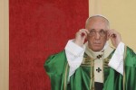 Pope Francis adjusts his glasses in front of his chair, which has an image of the Shroud of Turin woven into the red fabric, as he leads a mass during a two-day pastoral visit in Turin, Italy, June 21, 2015. REUTERS/Giorgio Perottino