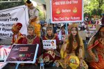 Protesters hold up signs during a demonstration against the military coup in Yangon on February 12, 2021. (Photo by Sai Aung Main / AFP)