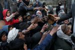 People reach out to receive bread in Kabul, Afghanistan, January 31, 2022. REUTERS/Ali Khara     TPX IMAGES OF THE DAY