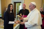 A handout picture taken on November 10, 2016 and released on November 11, 2016 by the Vatican press office Osservatore Romano shows Pope Francis receiving the "Bambi Award" from Syrian swimmer Yusra Mardini. 
Mardini gained international attention after surviving near-drowning while crossing the Mediterranean Sea with fellow refugees. She now lives in Germany and competed in this year's Rio Olympics as part of a refugee team. More than 300,000 people have been killed and over half Syria's population displaced by the conflict since it began with anti-government demonstrations in March 2011. / AFP PHOTO / OSSERVATORE ROMANO / OSSERVATORE ROMANO